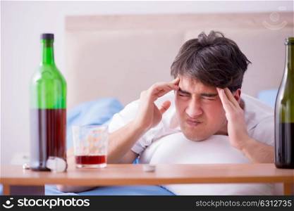 Man alcoholic drinking in bed going through break up depression