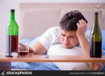 Man alcoholic drinking in bed going through break up depression