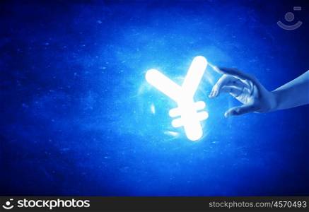 Man&amp;#39;s hand taking yen glowing simbol on blue background