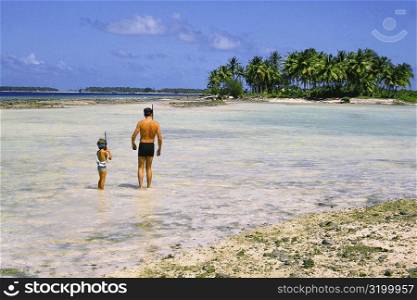 Man and a child standing on the beach, Majuro, Marshall Islands