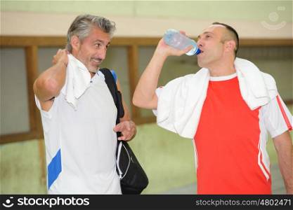 man and a friend drinking water after sport session