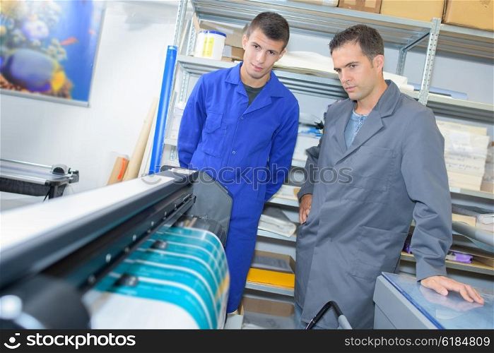 Man and apprentice watching printing machine