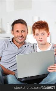 Man and child at home with laptop computer