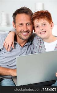 Man and child at home with laptop computer