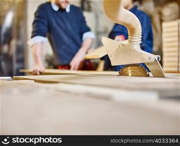 Man and female trainee preparing wood in printing workshop