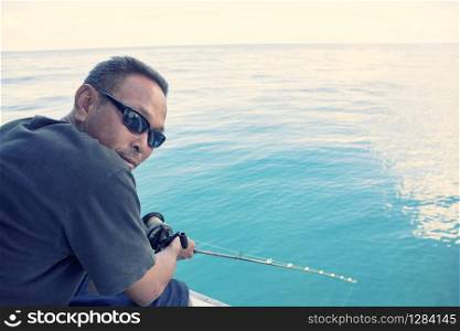 man and fishing rod in hand with wide blue sea scene. man and fishing rod in hand with wide blue sea scene