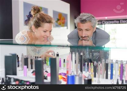 Man and lady gazing into counter of vaporisers