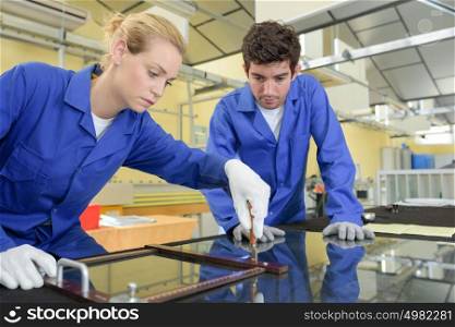 Man and lady working with glass