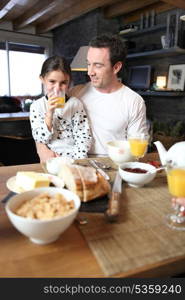 Man and little girl having breakfast