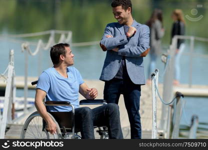 man and man in a wheelchair outdoors