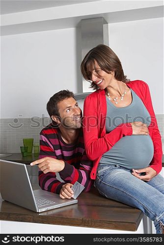 Man and Pregnant Woman Using Laptop