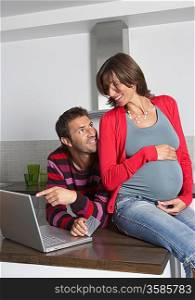 Man and Pregnant Woman Using Laptop