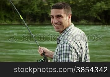 Man and sport, mid adult fisherman on holiday on river, relaxing and catching fish, smiling while holding fishing rod. Part 8 of 8