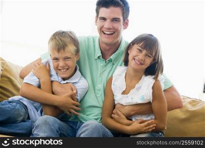 Man and two young children in living room smiling
