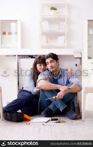 Man and woman assembling furniture at home