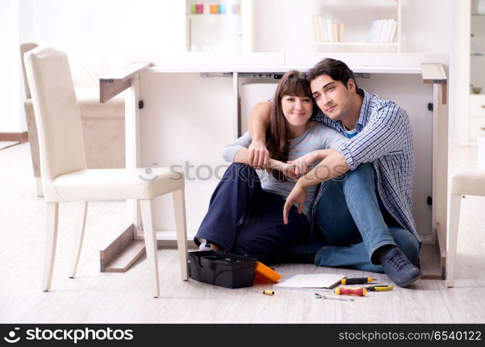 Man and woman assembling furniture at home