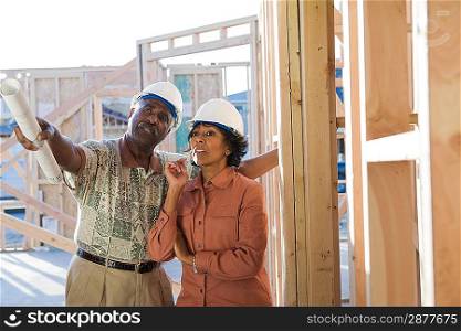 Man and woman at construction site, talking