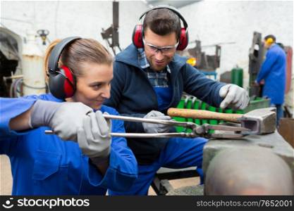 man and woman at metal workshop