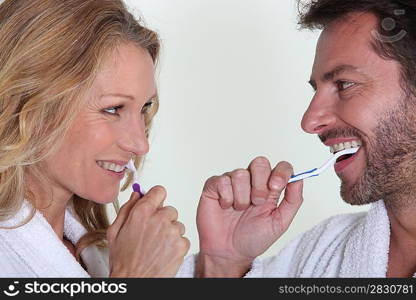 Man and woman brushing teeth