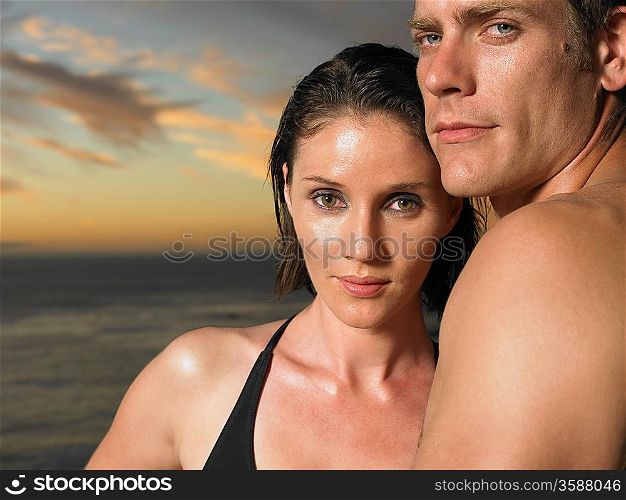 Man and woman by ocean at sunset close-up