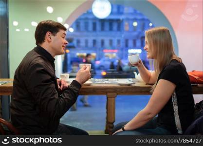Man and woman chatting over a cup of coffee inside a cafe or restaurant
