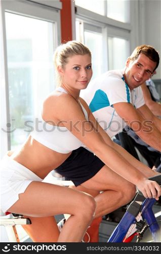 Man and woman doing indoor biking