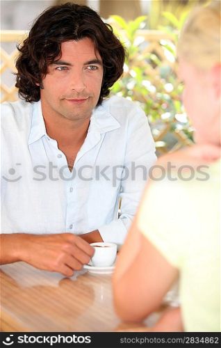 Man and woman drinking coffee outside