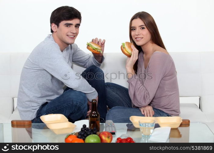 Man and woman eating hamburgers