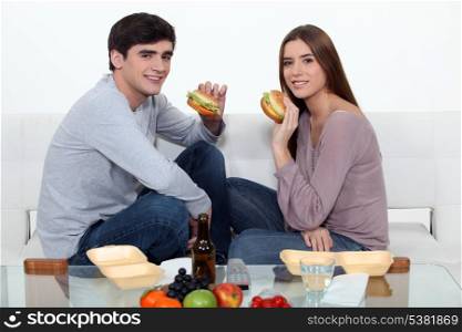 Man and woman eating hamburgers