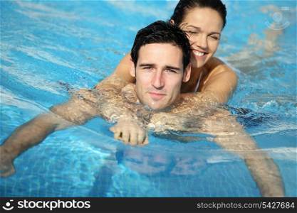 Man and woman embraced in swimming pool