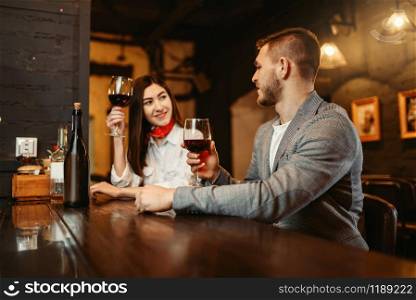 Man and woman flirting in bar, couple at wooden counter. Lovers leisures in pub, husband and wife relaxing together in nightclub