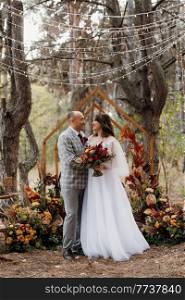 man and woman got engaged in autumn forest at wedding decorated ceremony