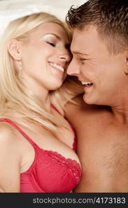Man and woman having fun in bed during foreplay