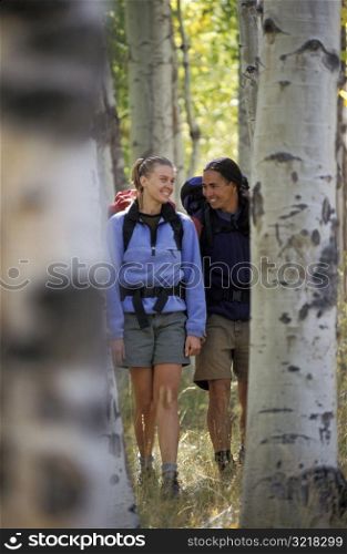 Man and Woman Hiking Through Aspens
