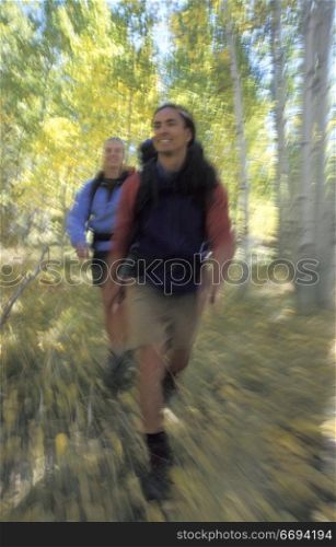 Man and Woman Hiking Through Aspens
