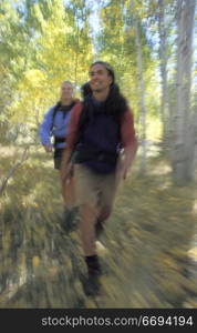 Man and Woman Hiking Through Aspens