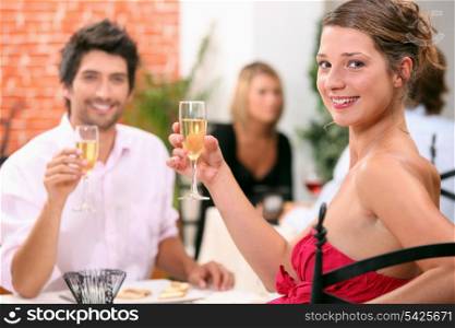 Man and woman holding champagne glasses in restaurant