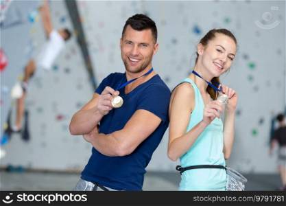 man and woman holding medal as winners