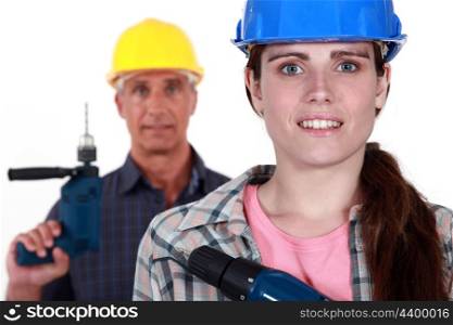 Man and woman holding power drills