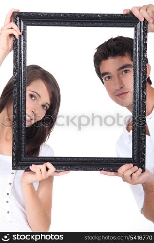 Man and woman holding up a picture frame