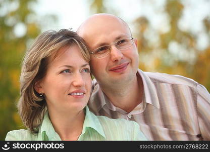 man and woman in early fall park. they are cuddling.