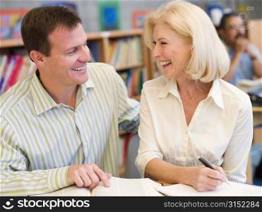 Man and woman in library laughing (selective focus)