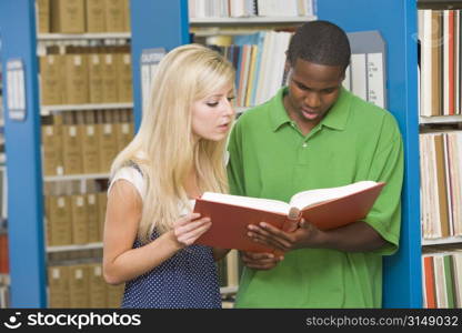 Man and woman in library reading book (depth of field)