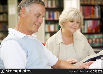Man and woman in library reading (selective focus)