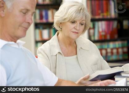 Man and woman in library reading (selective focus)