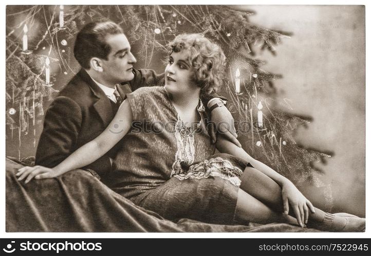 Man and woman in love celebrated with christmas tree. Romantic centemental vintage picture with original film grain and blur