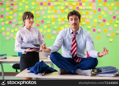 Man and woman in the office with many conflicting priorities in yoga concept  . Man and woman in the office with many conflicting priorities in 