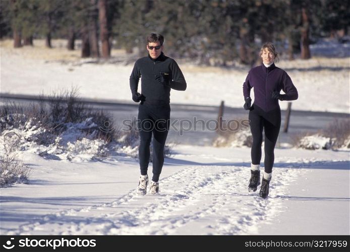 Man and Woman Jogging in the Snow