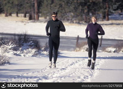 Man and Woman Jogging in the Snow