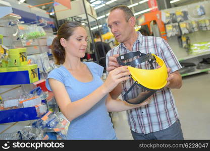 Man and woman looking at protective helmet